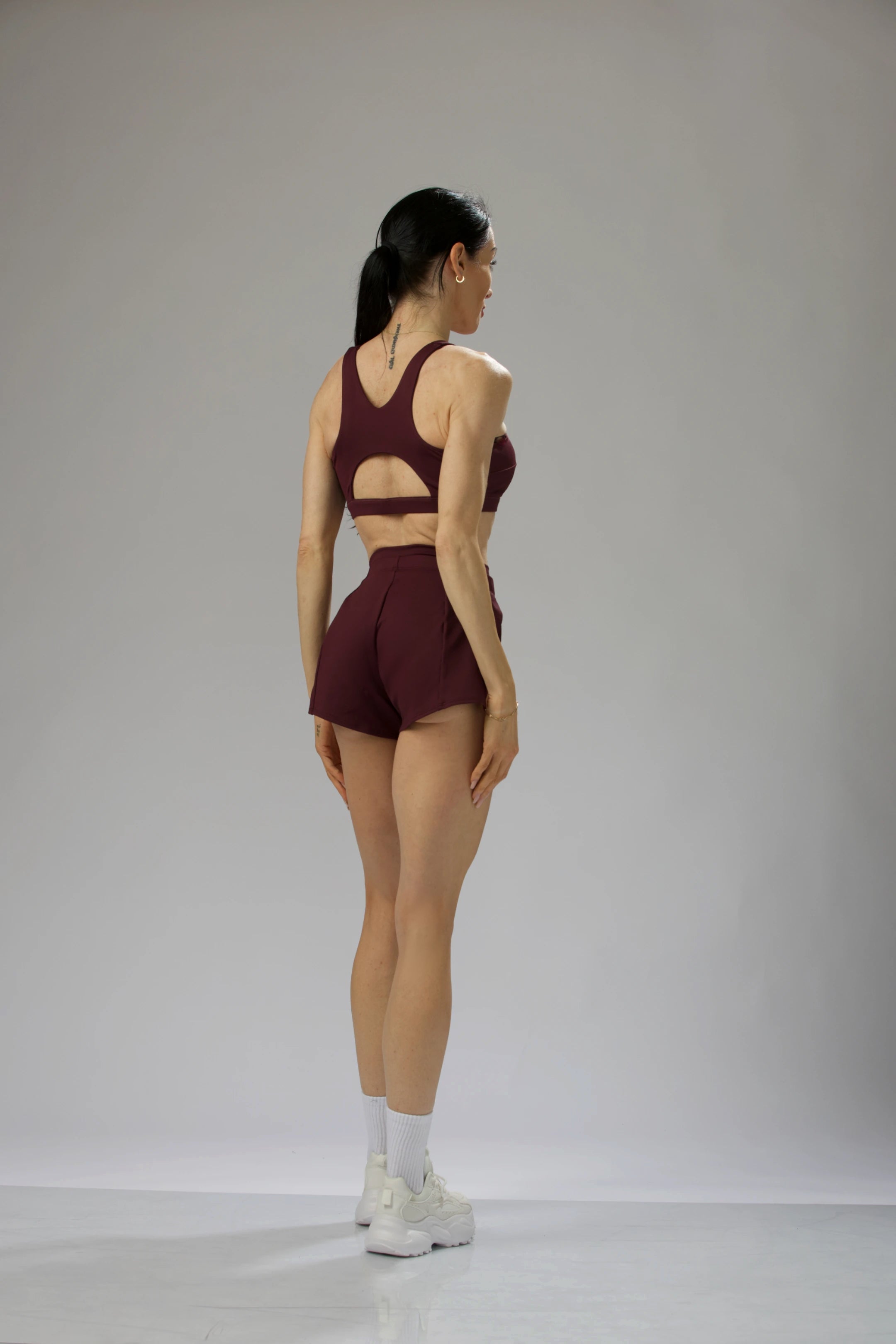 Reaux high-waisted sculpted bloomer shorts in deep purple, featuring a tailored slit design and built-in liner for coverage and movement.