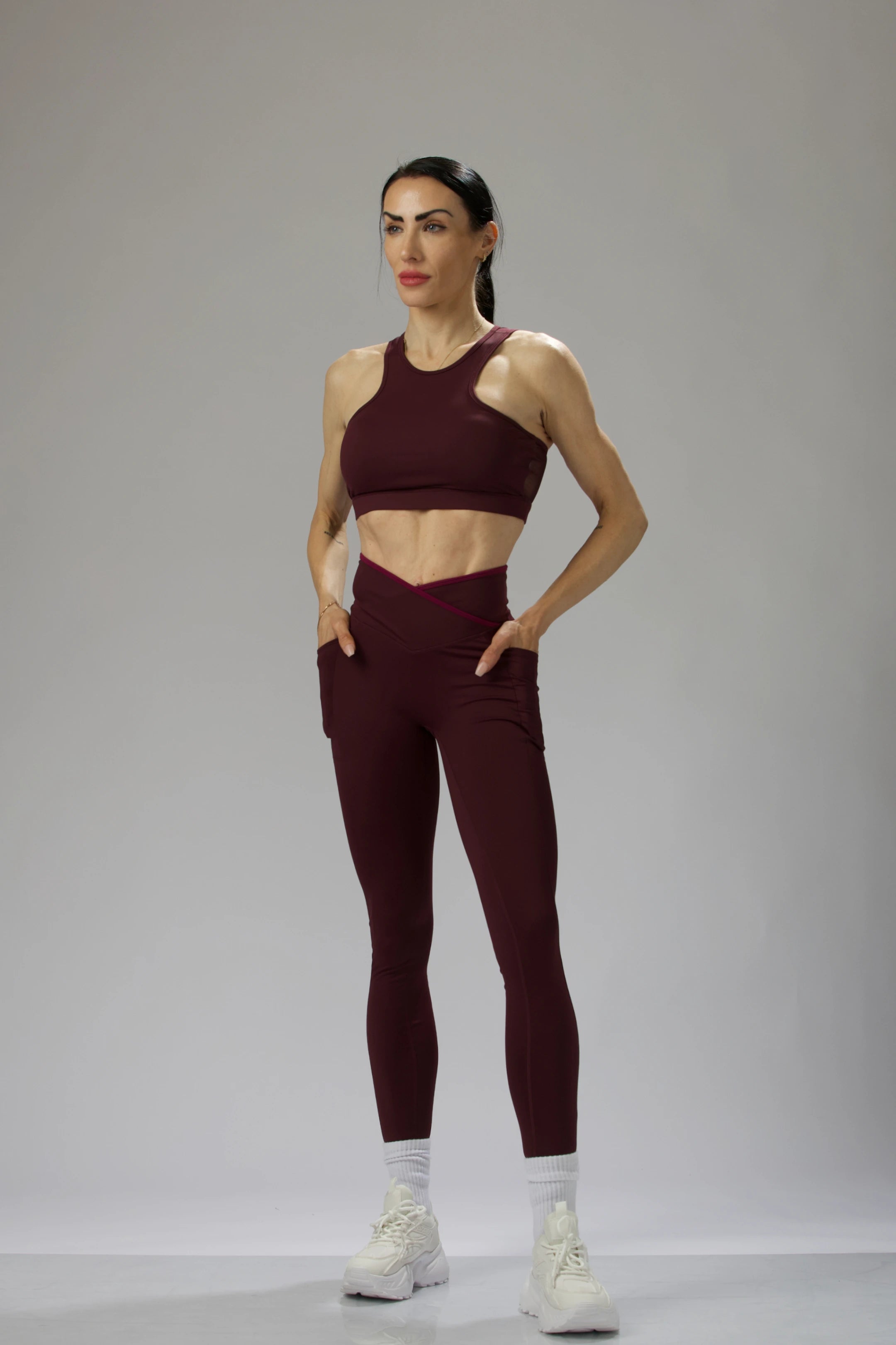 Side angle of Reaux burgundy leggings, featuring a sculpting high-waisted design for a refined silhouette.
